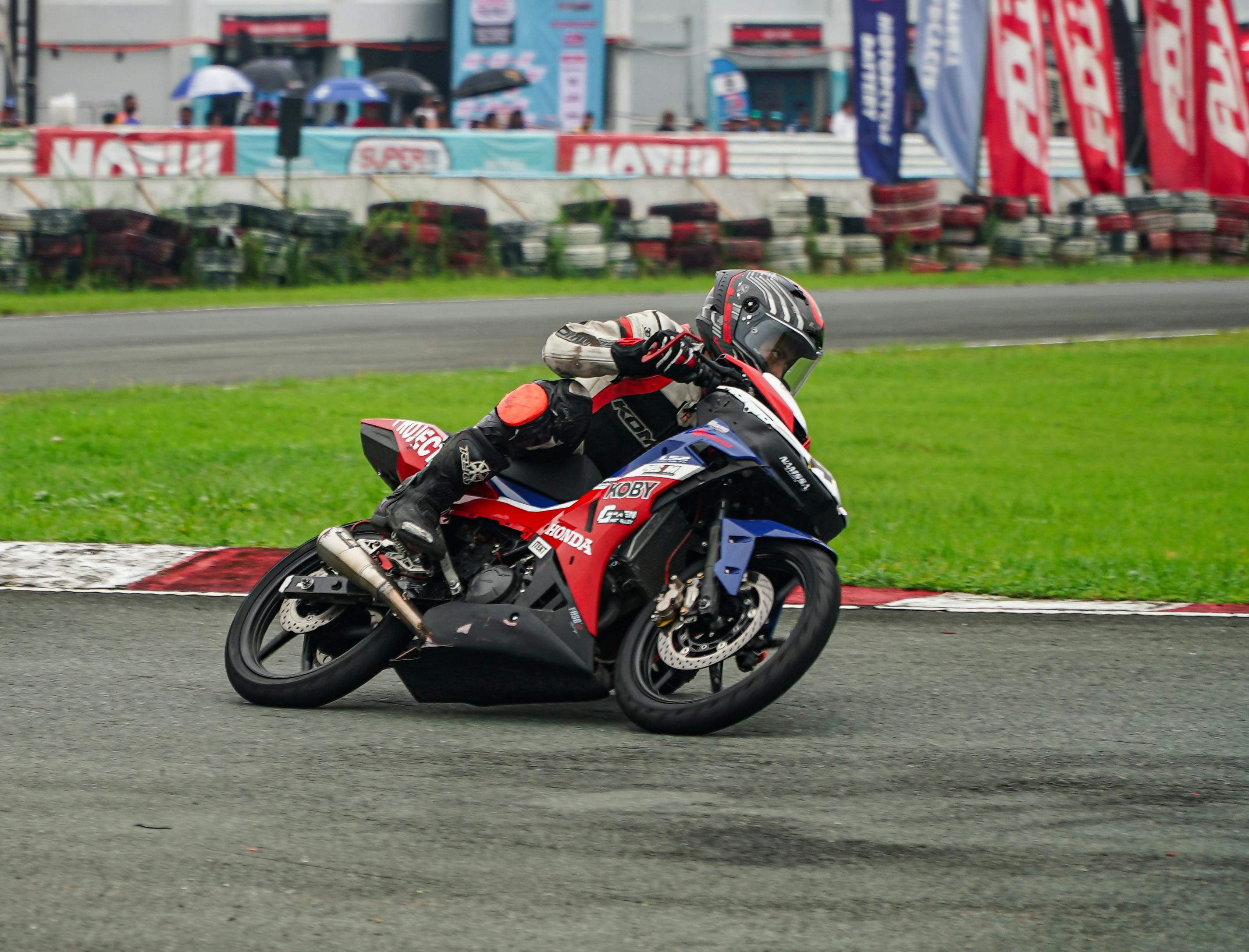 Motorcyclist navigating a turn at Tarlac Circuit in the Philippines during a race.