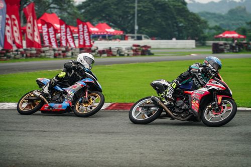 Free Two motorcyclists race on a track in Tarlac City, showcasing speed and skill. Stock Photo