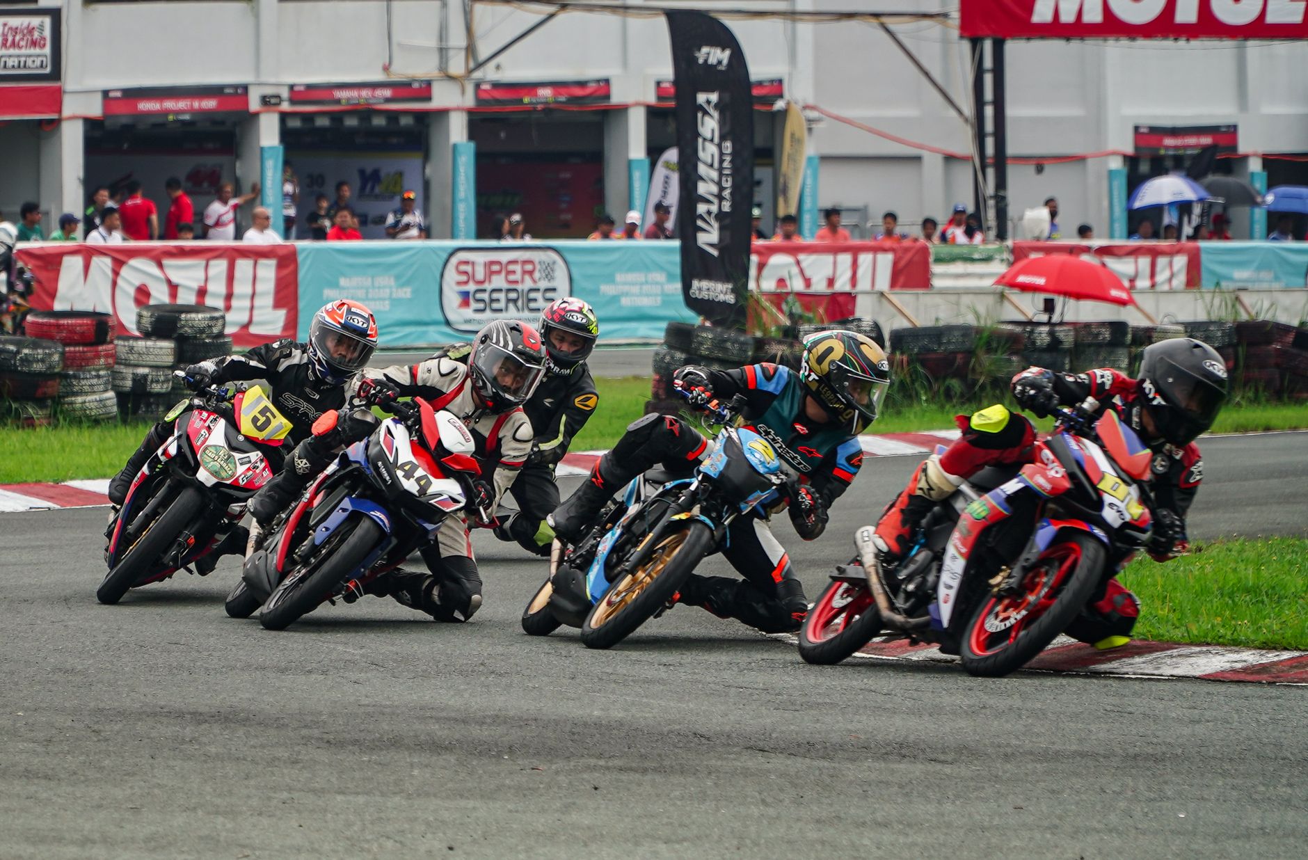 Thrilling motorcycle race in Tarlac City with riders taking sharp turns on the racetrack.