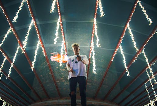 夜晚，一名年轻人在一座灯火通明的桥下，巧妙地表演了火戏法