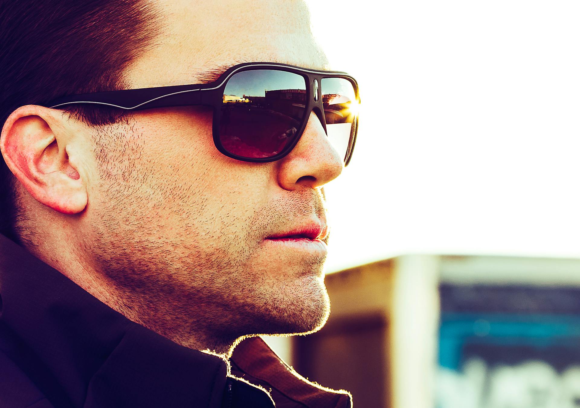 Close-up portrait of a man wearing sunglasses in a casual outdoor setting.