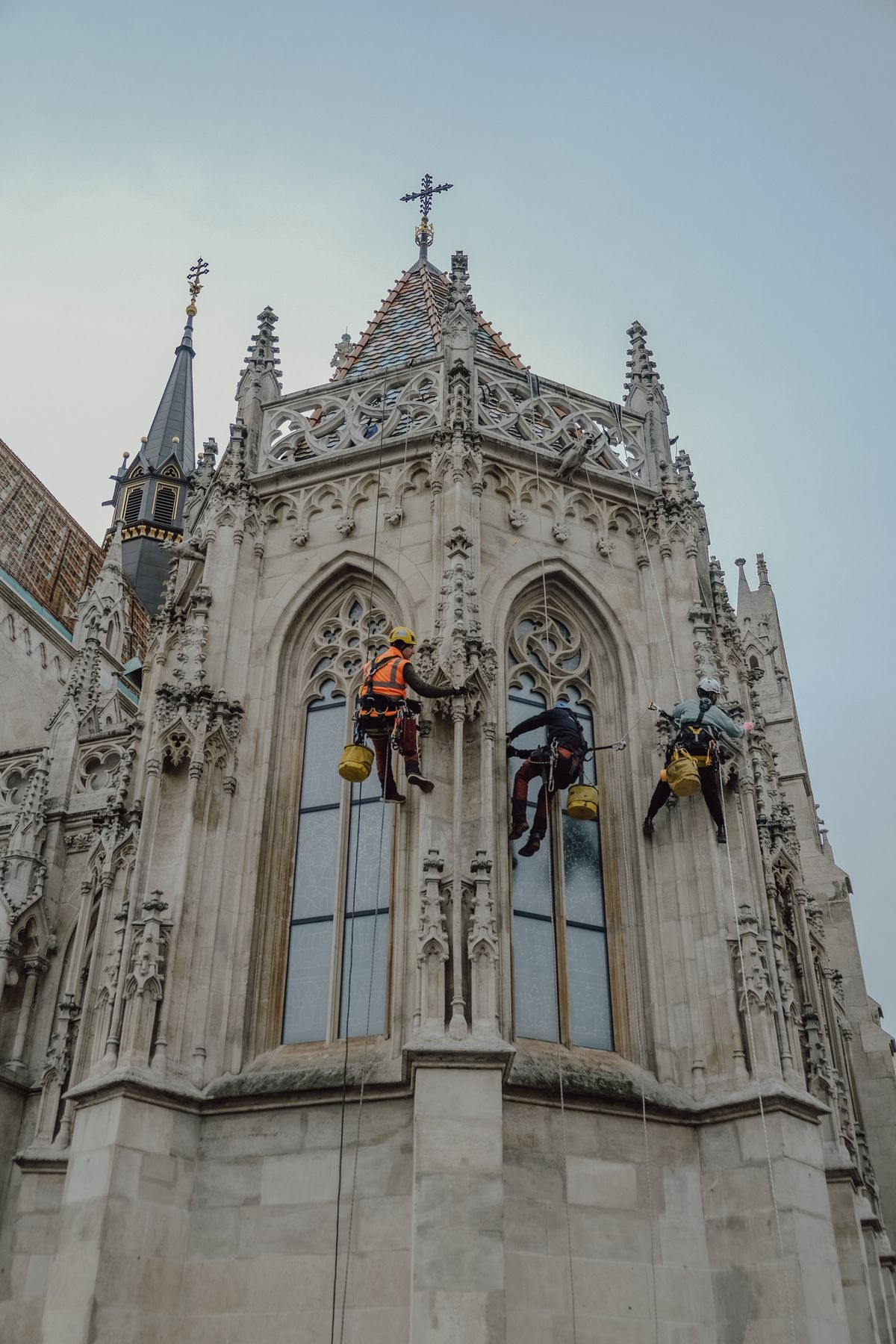 Stock photograph of workers maintaining the exterior of a historic church building