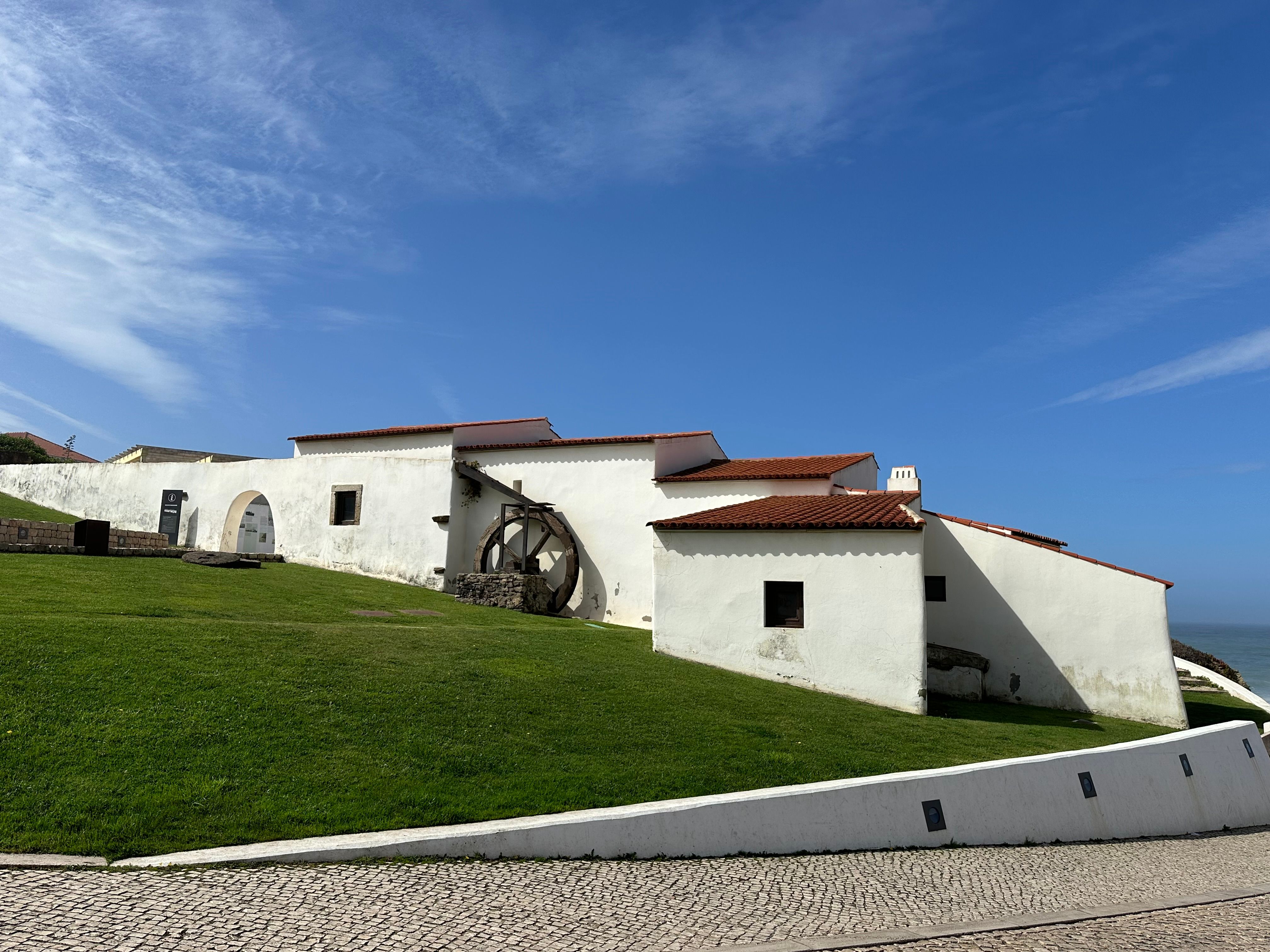 Charming white buildings with terracotta roofs in Ericeira, Portugal, set against a clear blue sky. - Ericeira