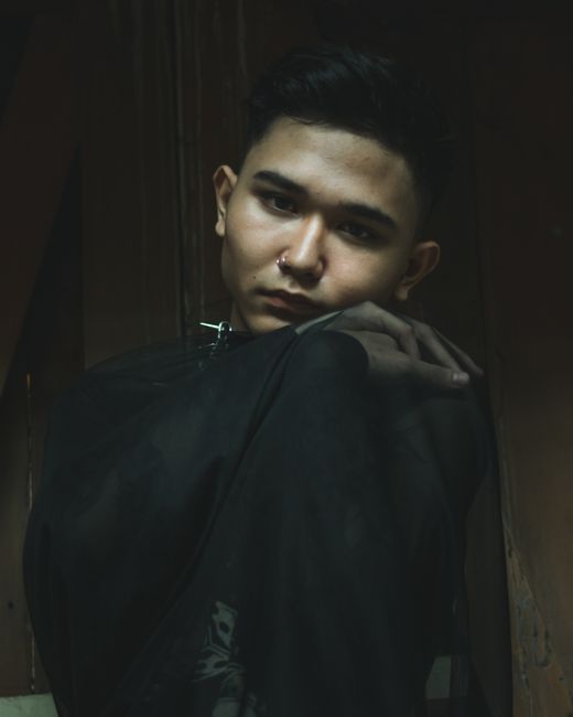 Dramatic portrait of a young man with a nose ring in low light