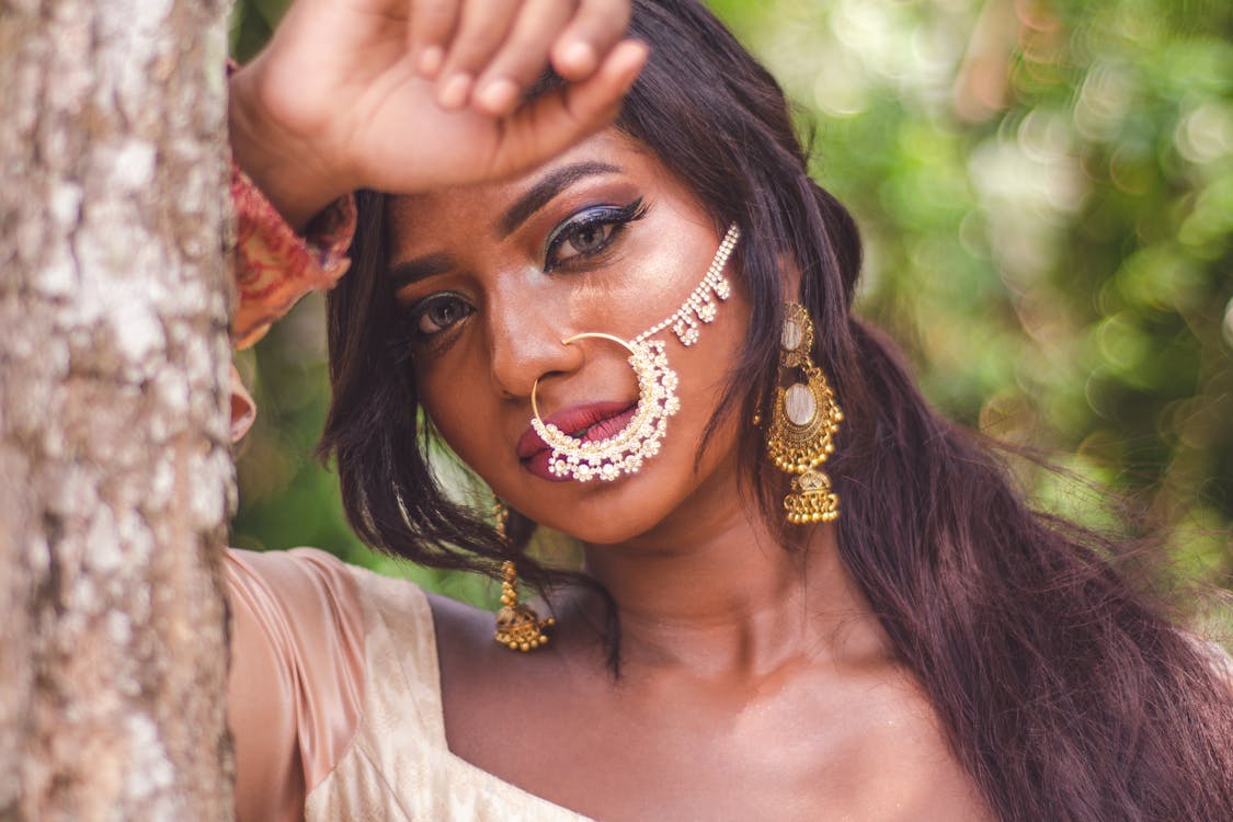 Selective Focus Close-up Portrait Photo of Indian Woman With Nose Ring Posing By Tree