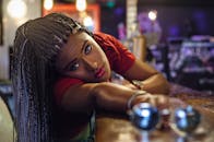 时尚的女人与编织的头发在温暖的灯光下在室内摆姿势，展示时尚和优雅