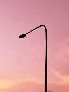 Streetlight silhouette against a vivid sunset sky in Hanoi, Vietnam.