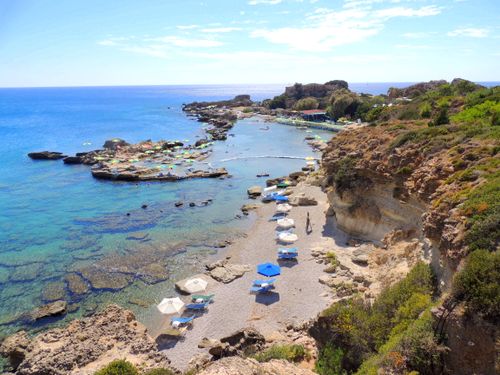Free A picturesque coastal scene in Rhodes, Greece, featuring sunlit beaches and clear blue waters. Stock Photo