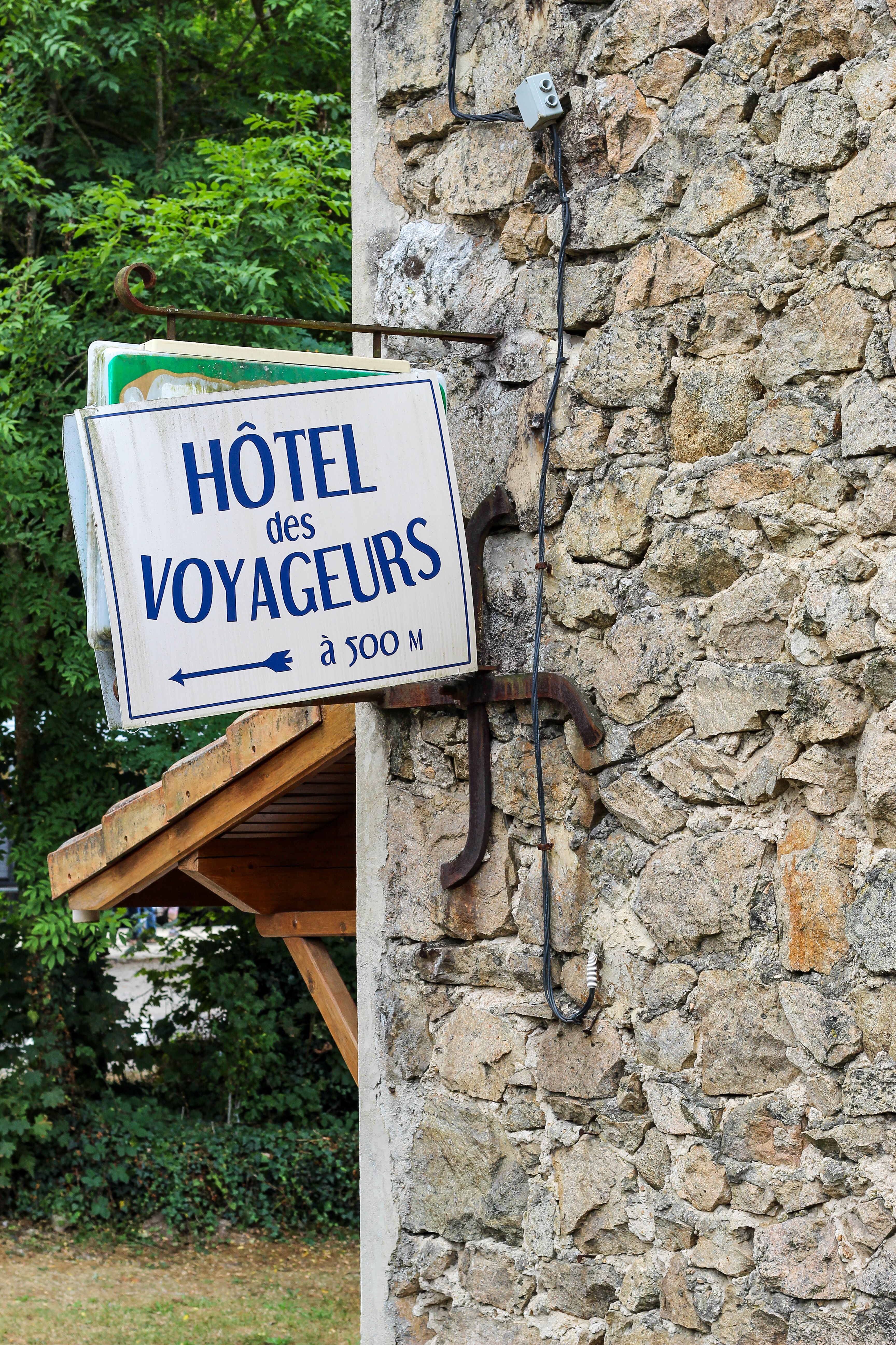 Stone wall with a hotel sign in Tournon-sur-Rhône, capturing French ambiance.