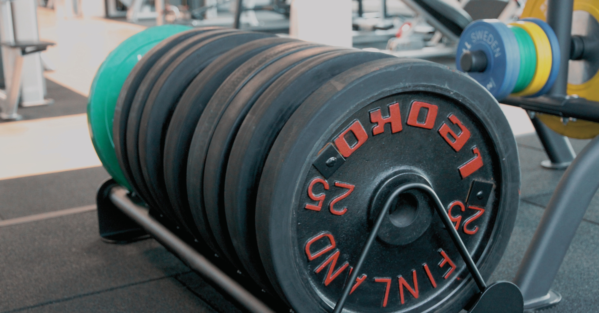 Close-up of stacked weight plates in a modern gym setting.