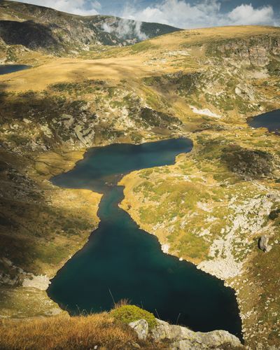 Still alpine lake beneath grey peaks — photo by Mladen Janic on Pexels