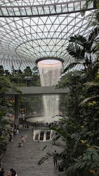 Explore the breathtaking indoor waterfall at Jewel Changi Airport, surrounded by lush greenery and modern architecture.