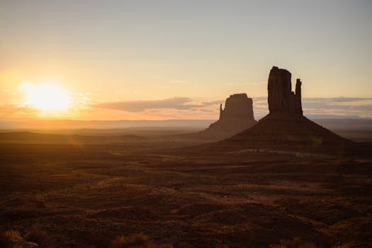 Beautiful sunrise landscape of Monument Valley with iconic rock formations in warm tones.