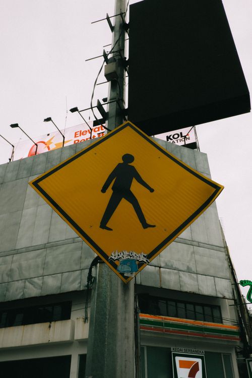 Free Vintage-style photo of a pedestrian crossing sign in a Malaysian city scene. Stock Photo
