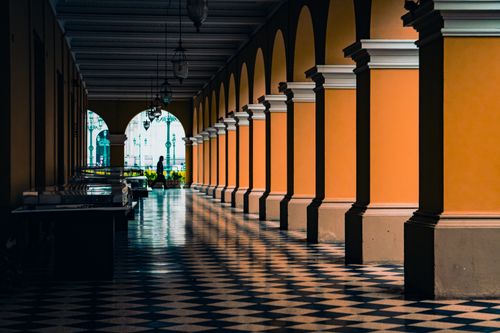 Free Elegant hallway with arches and checkered floor, showcasing classic architectural design. Stock Photo