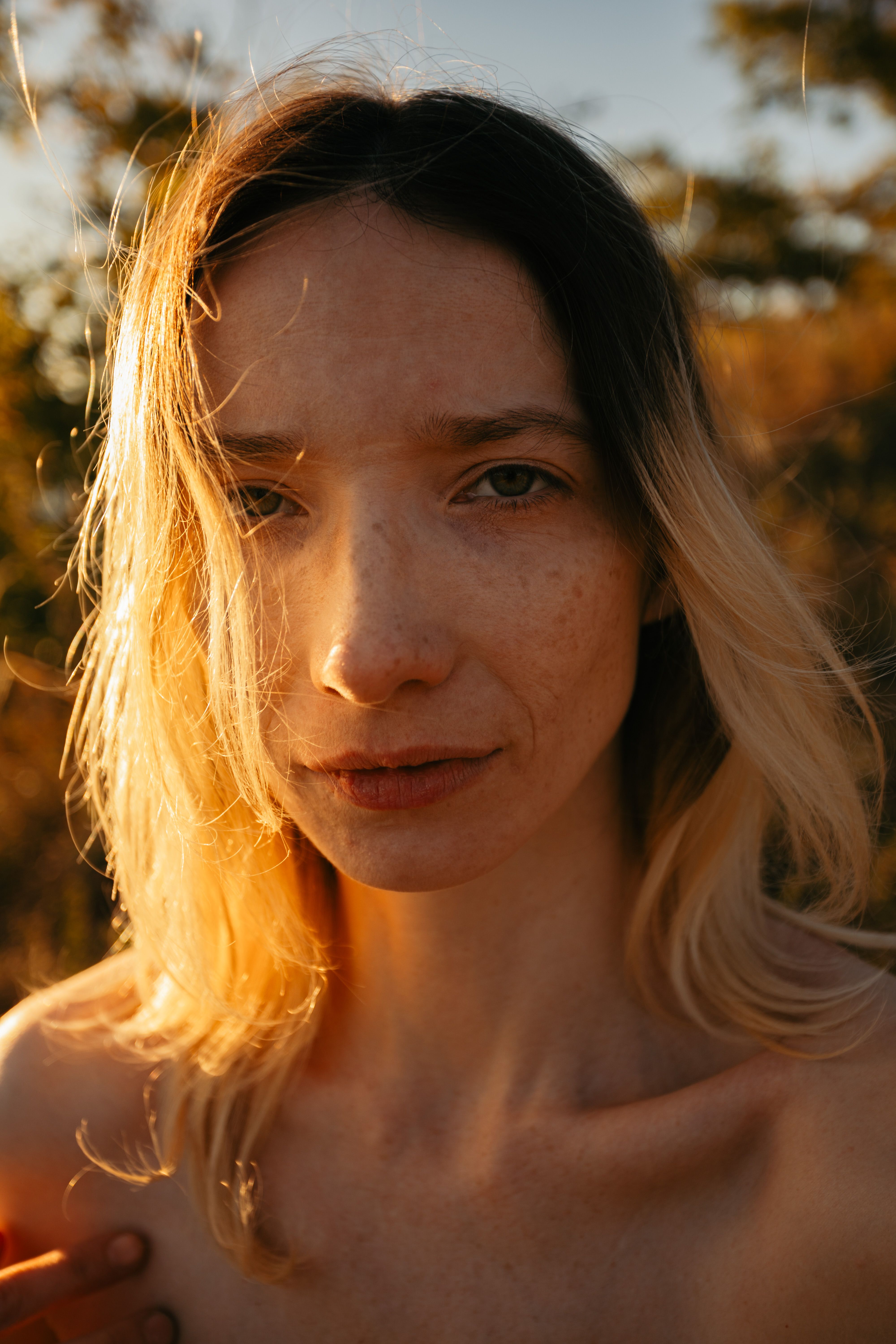 Close-up portrait of a woman during golden hour with sunlight illuminating her face.