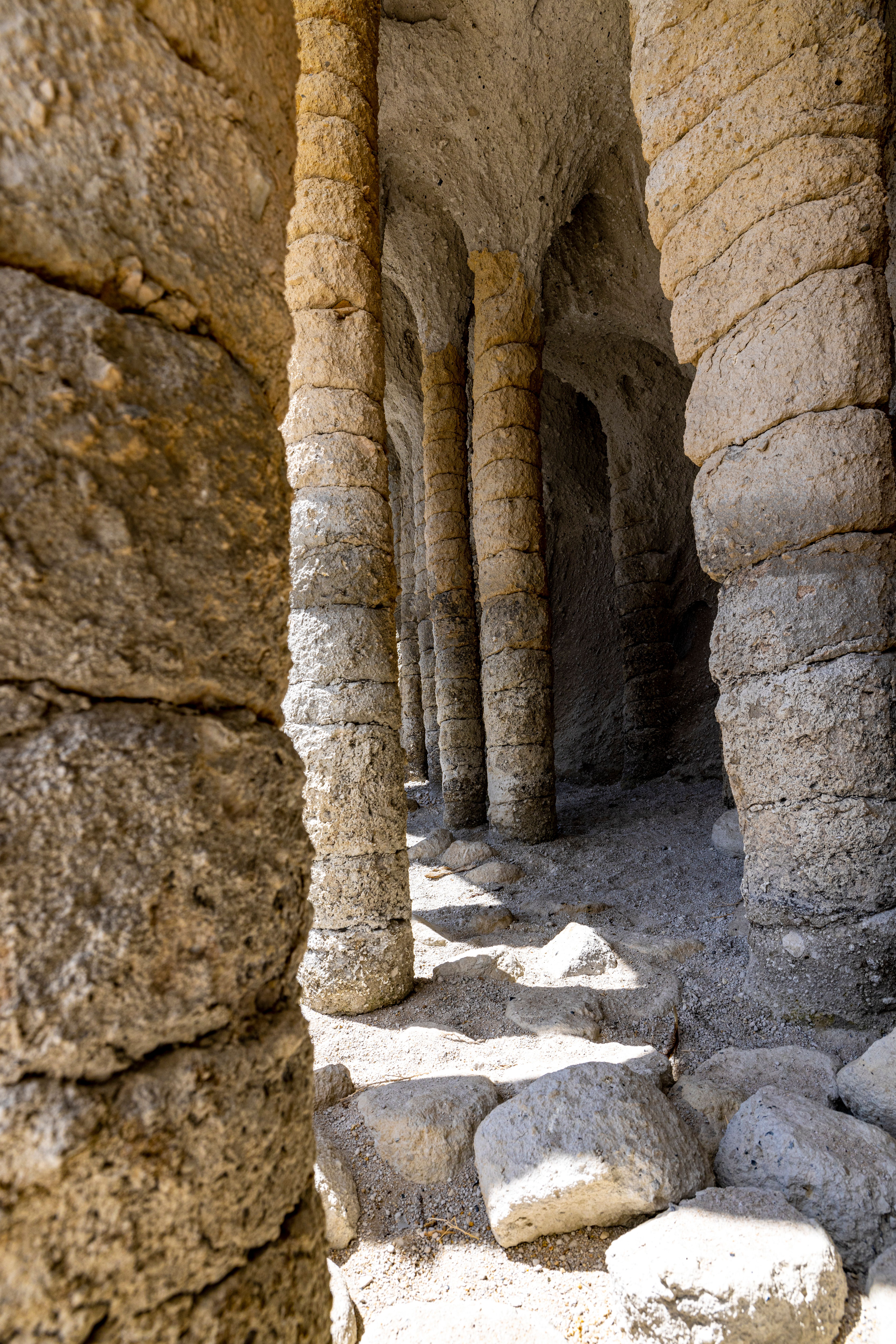 Ancient Stone Columns in Sunlit Cave · Free Stock Photo
