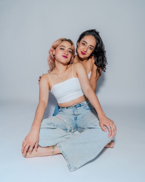 Free Two women sitting together in a studio, showcasing friendship and empowerment. Stock Photo