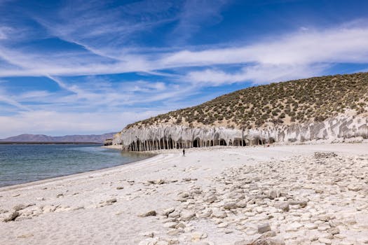 Scenic view of caldera beach with striking rock formations and clear blue sky.