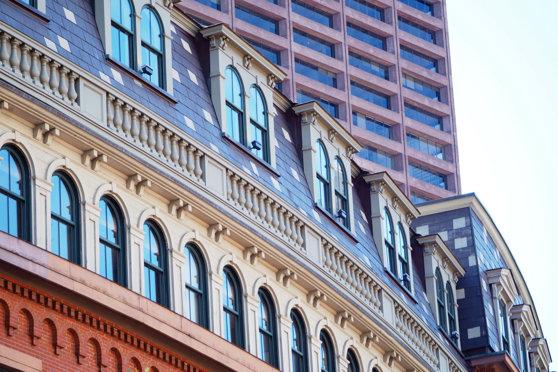 Curved facade of historic building with modern skyscraper in Boston, Massachusetts.