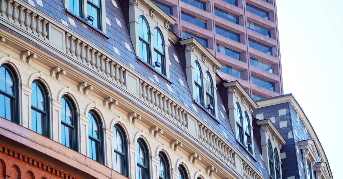 Curved facade of historic building with modern skyscraper in Boston, Massachusetts.