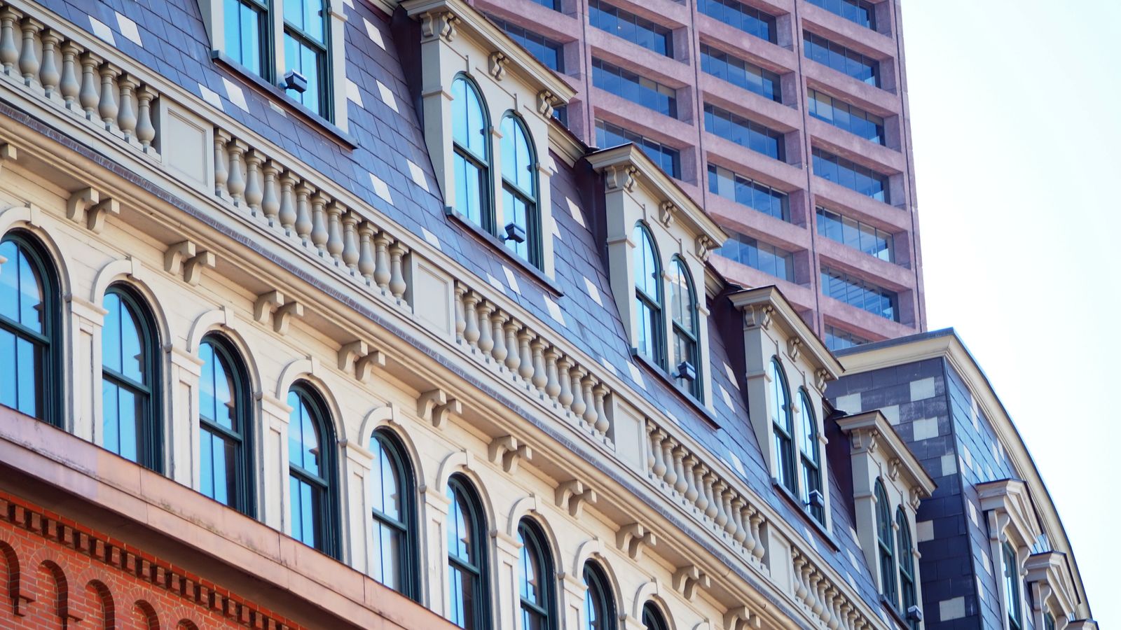 Curved facade of historic building with modern skyscraper in Boston, Massachusetts.
