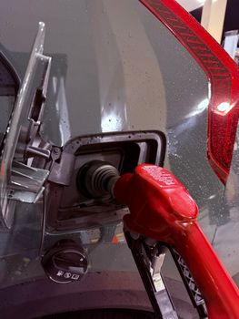 Close-up image of a car being refueled at a gas station. Ideal for energy and transportation themes.