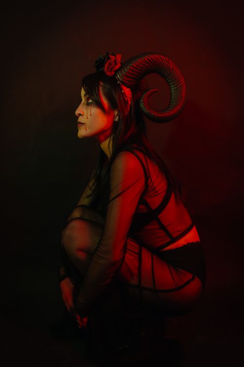 Free Dark artistic portrait of a woman wearing ram horns, captured with moody lighting. Stock Photo