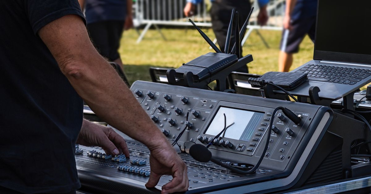 Wenn Technik unsichtbar wird: Berlins Elektro-Boom und die Fertigung im Hintergrund 2 Tontechniker bedient Mischpult beim Aufbau eines Open-Air-Konzerts im Freien