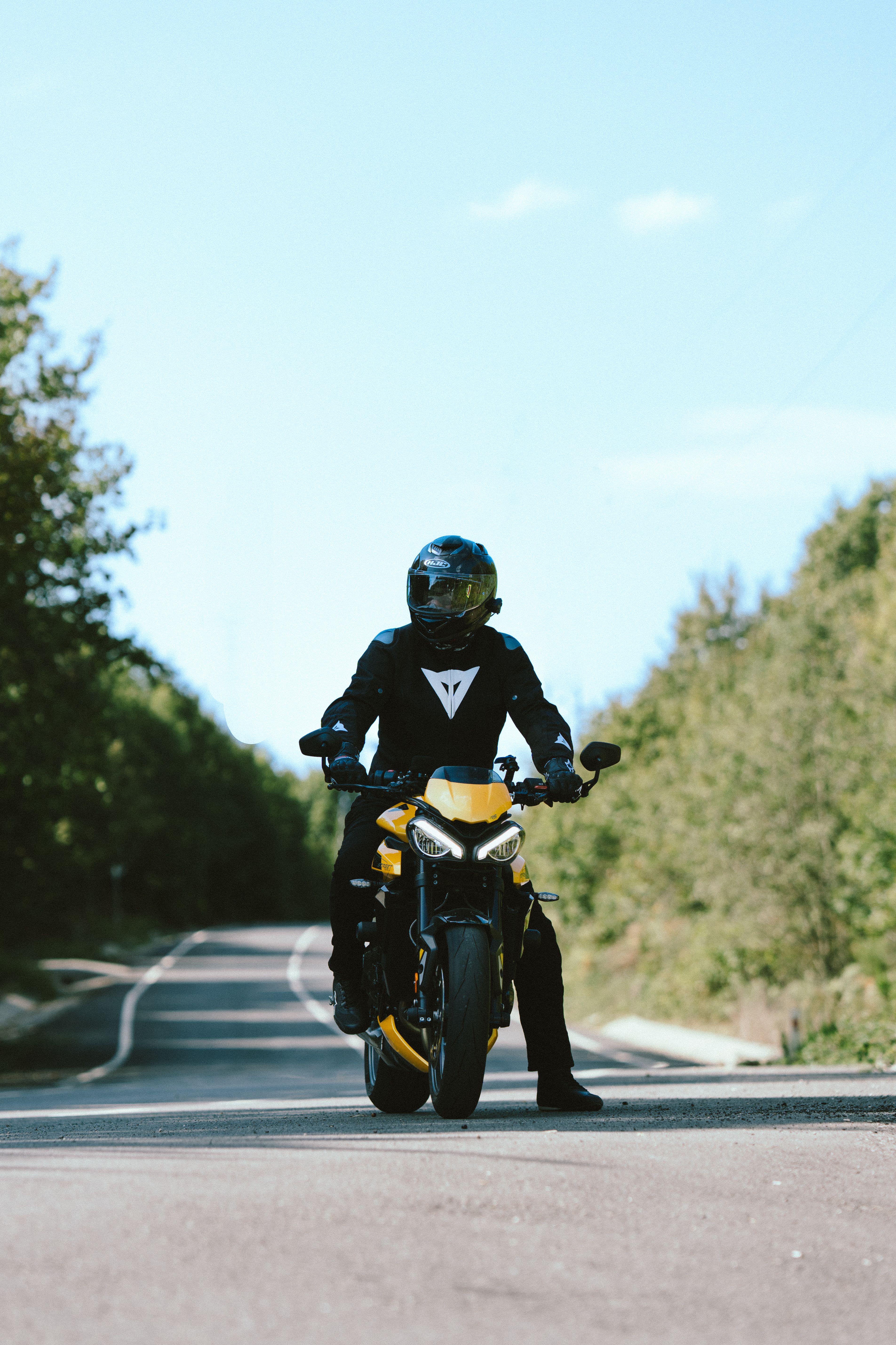 Motorcyclist on Yellow Bike Riding Scenic Road · Free Stock Photo