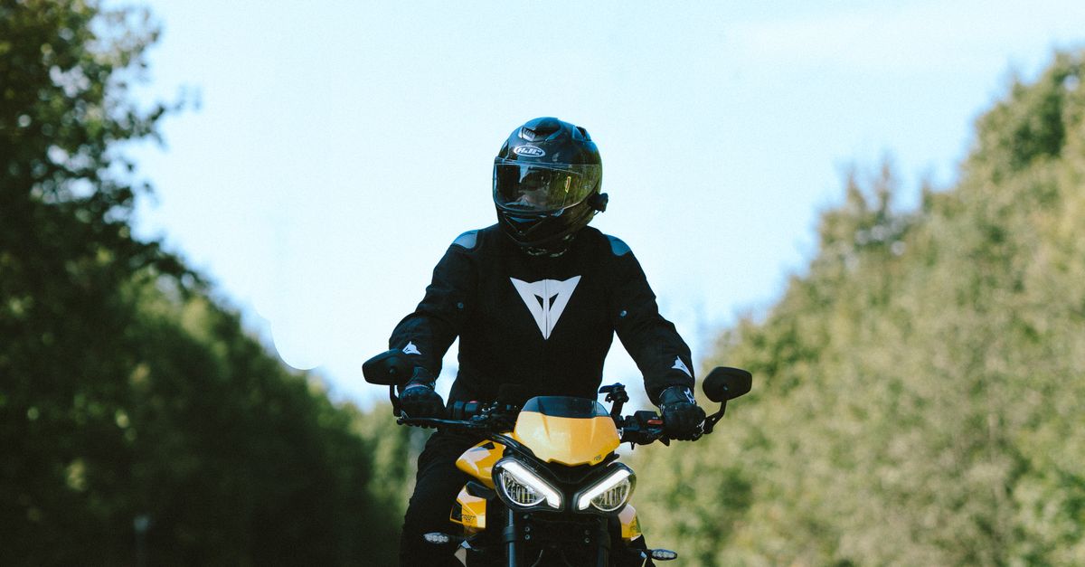Yellow Color Bike Rider Motorcyclist on Yellow Bike Riding Scenic Road · Free Stock Photo