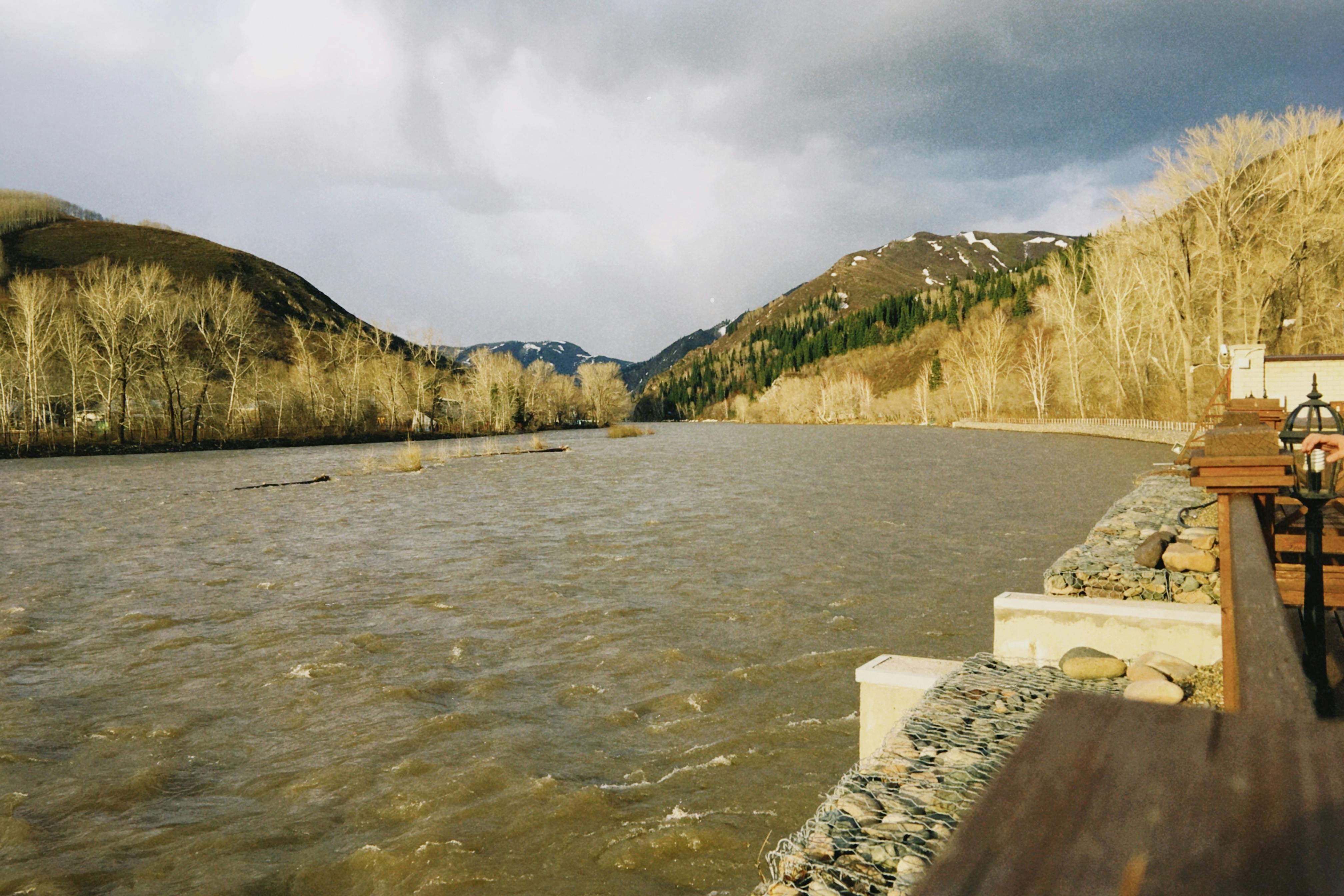 Beautiful river with mountainous landscape in Oskemen, Kazakhstan, under a cloudy sky.