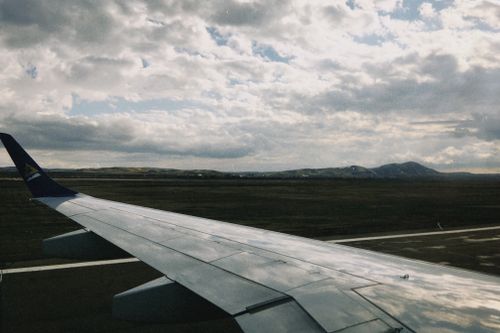 Free Aerial view from an airplane wing flying over Oskemen, Kazakhstan, showcasing vast landscapes and dramatic skies. Stock Photo