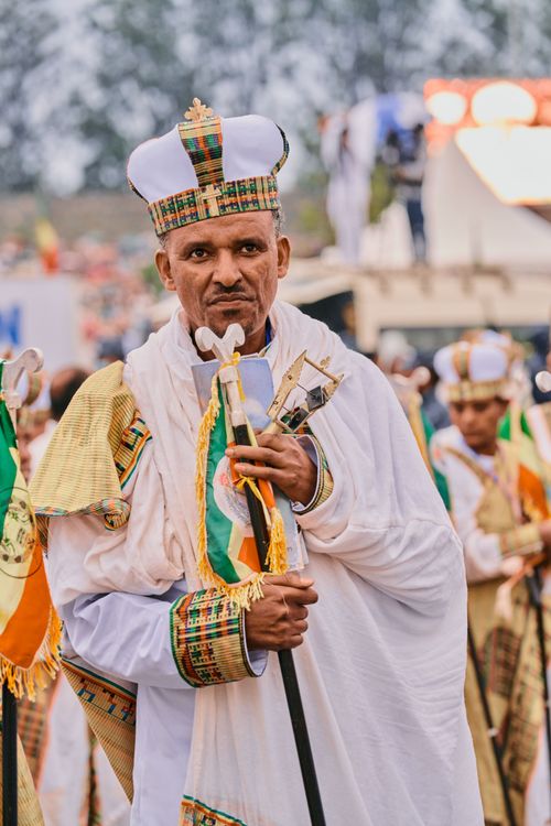 Free Man in traditional Ethiopian attire holding staff during outdoor ceremony Stock Photo