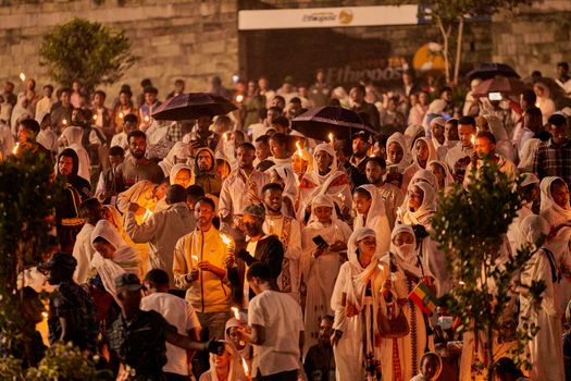A large crowd gathered at night for a traditional candlelight ceremony.