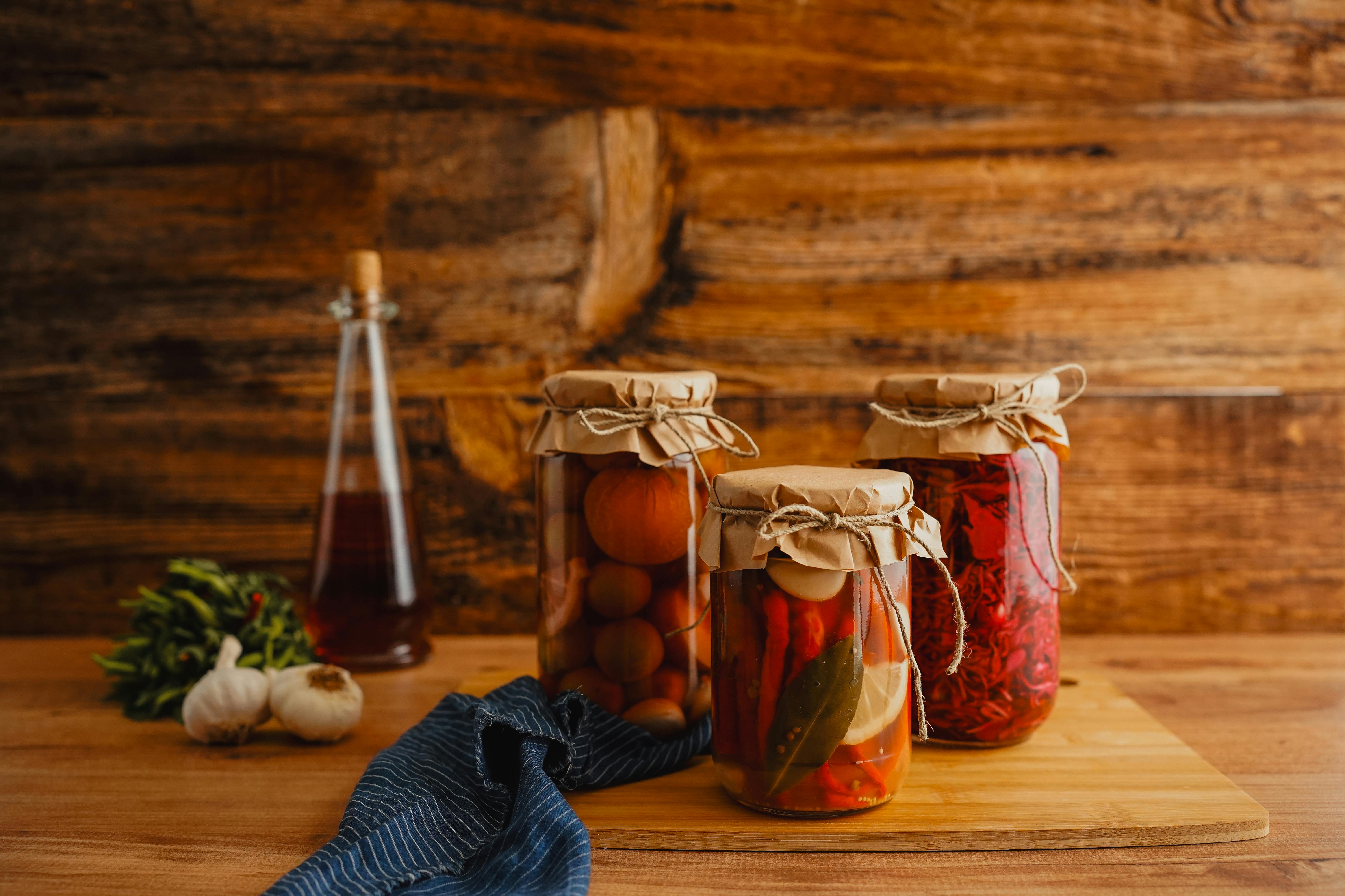 A close-up of pickled cherry peppers in jars