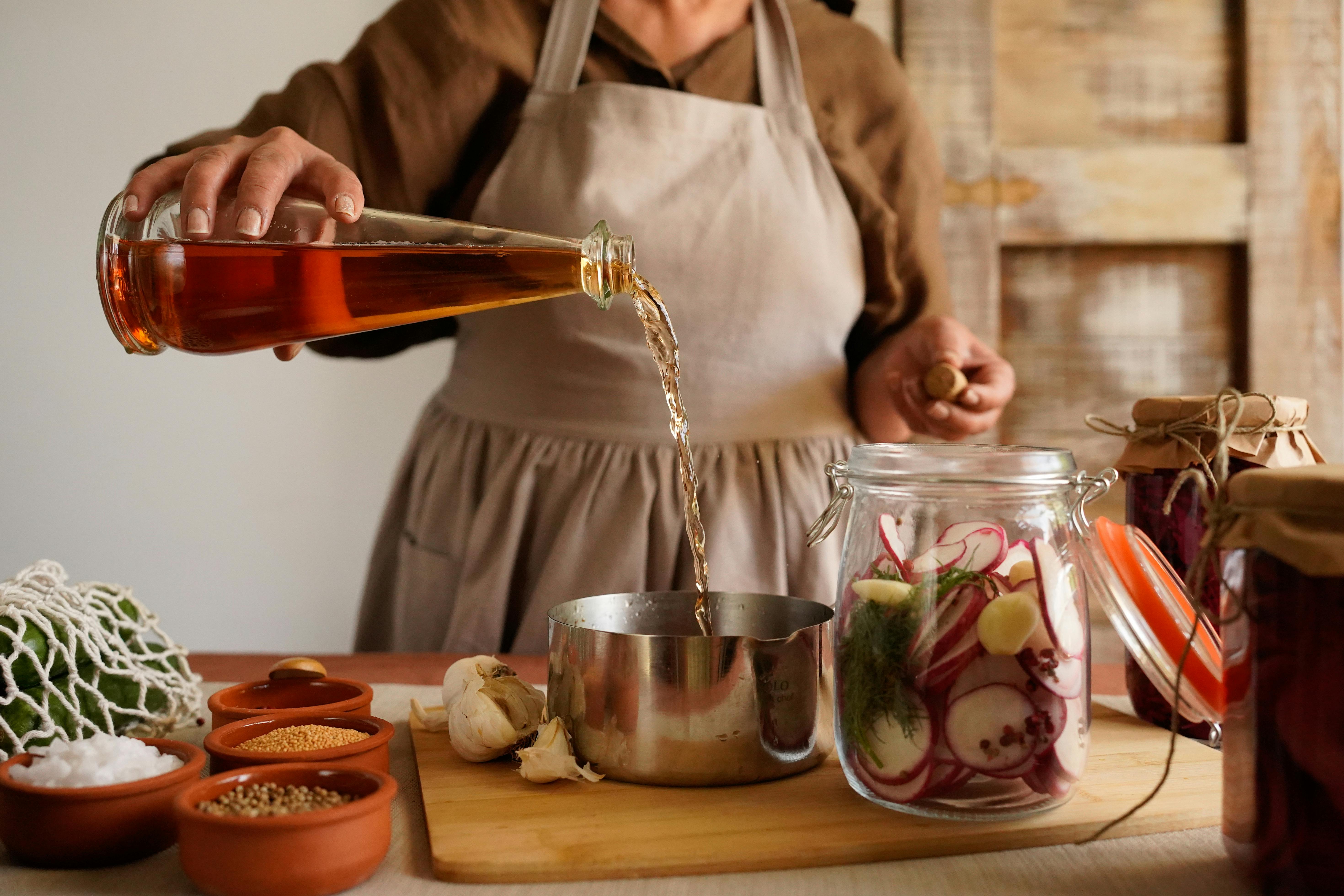 Free Woman Preparing Homemade Pickles in Rustic Kitchen Stock Photo