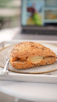 Tasty chicken sandwich with a glass of juice in a cozy cafe setting, perfect for dining experiences.