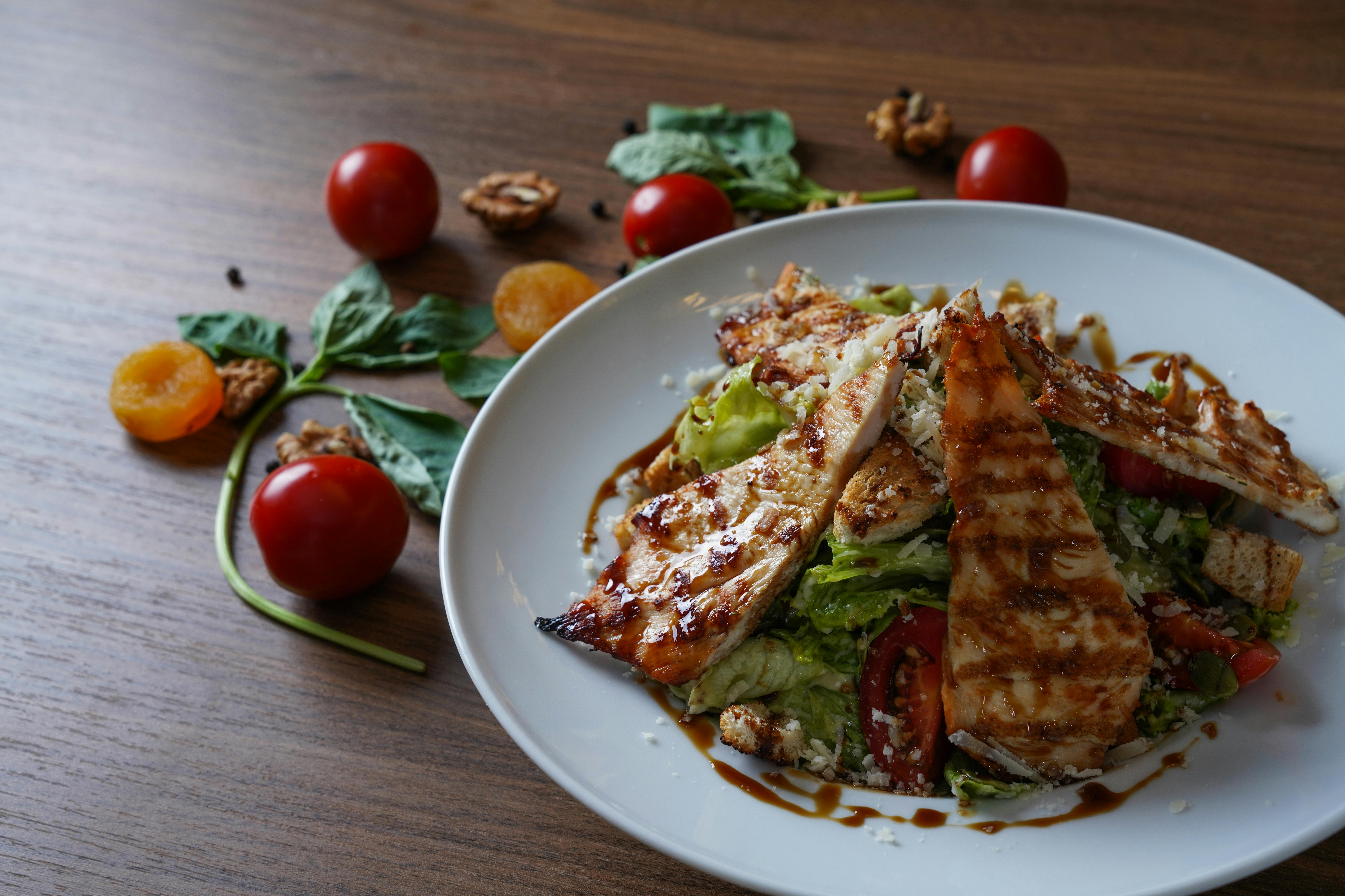 A happy family sitting around a dinner table, serving themselves from a large one-pot meal in the center.