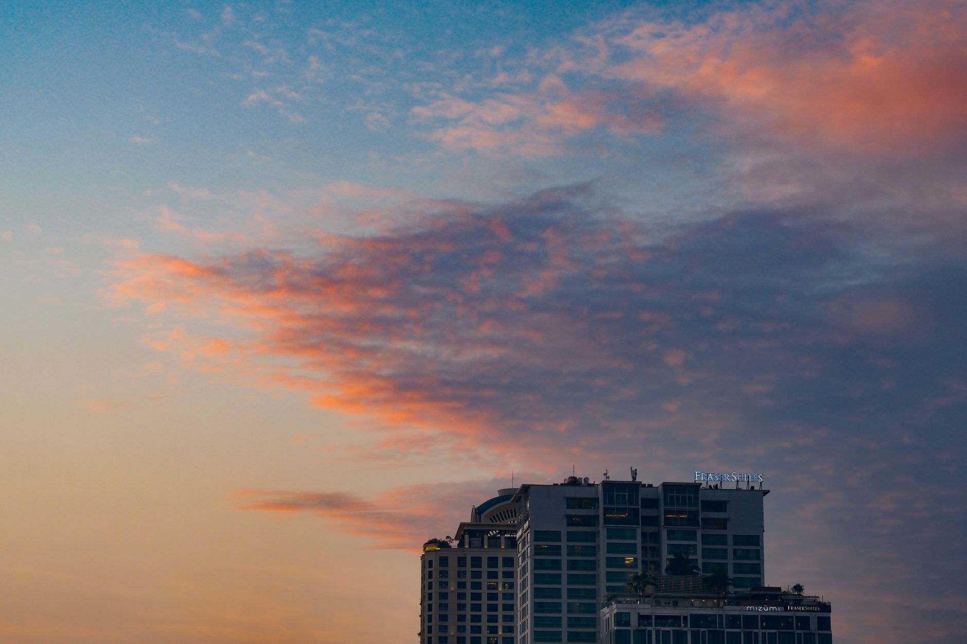 A sophisticated luxury hotel suite with a panoramic view of a global city at sunset