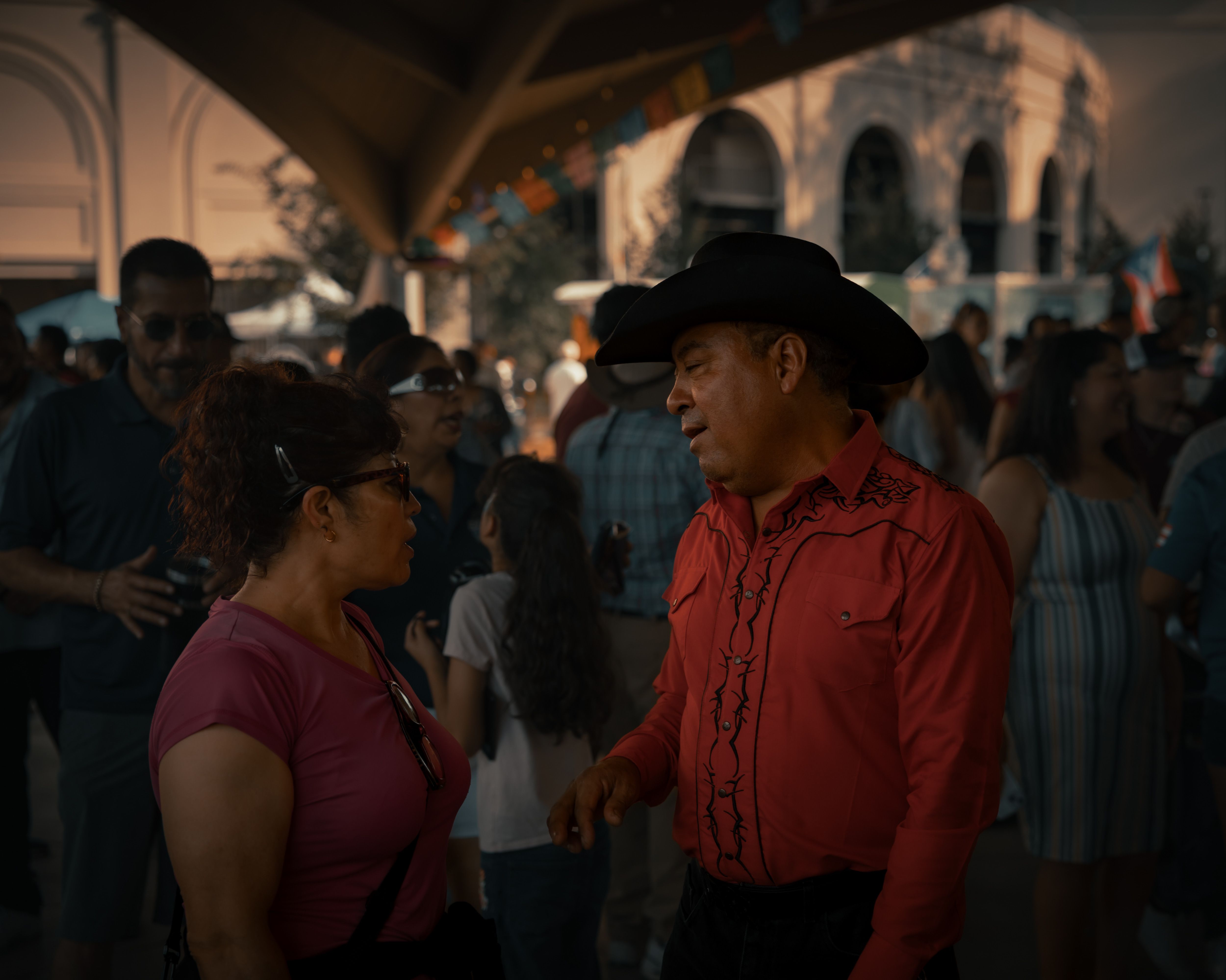 Diverse crowd of people in conversation at a busy street festival, the raw human chatter that stock sentiment analysis measures