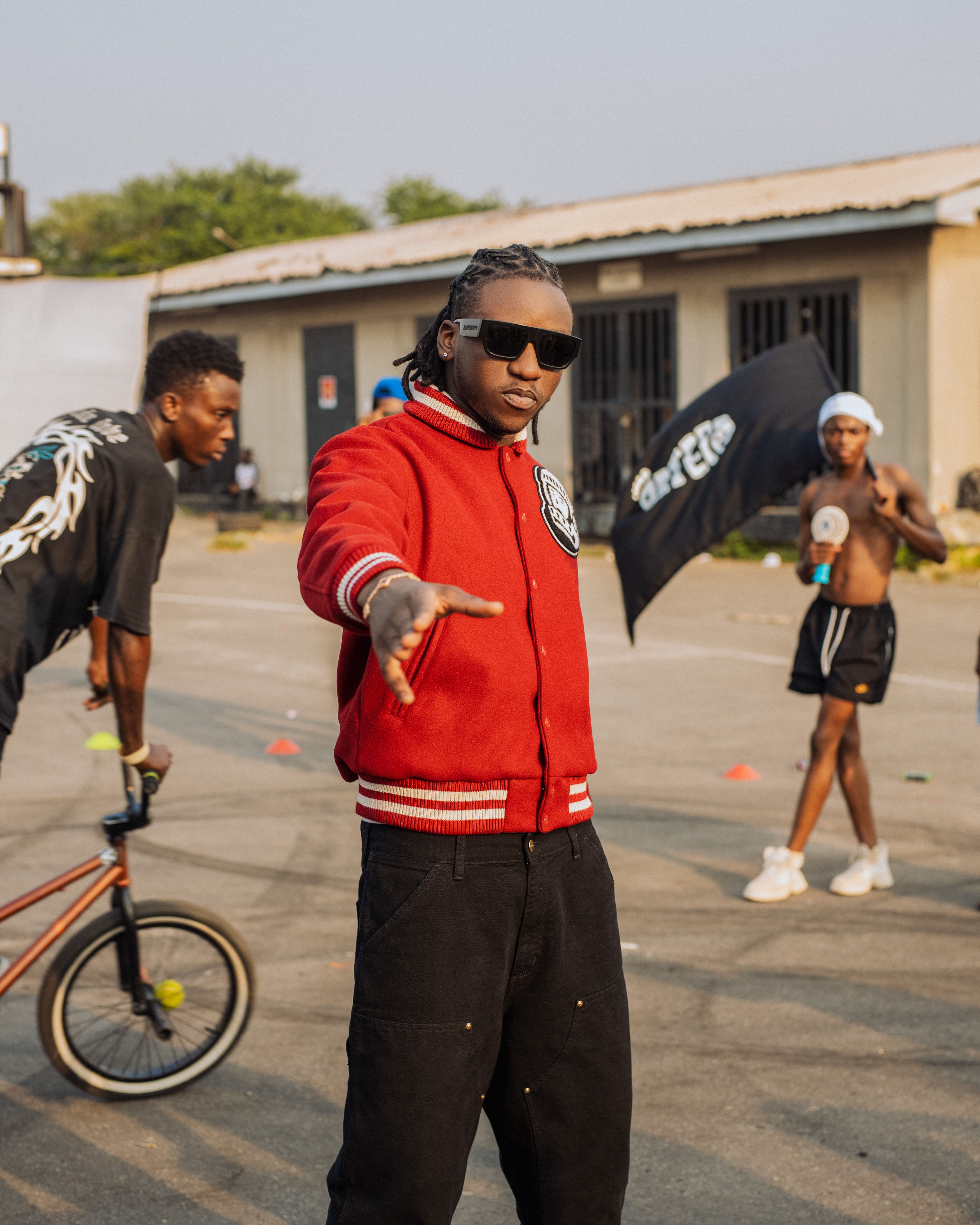 Young adults in urban setting with BMX and bold fashion style.