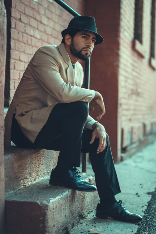 Free Portrait of a fashionable man in formal wear sitting on brick stairs in New York. Stock Photo