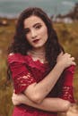穿着红色蕾丝连衣裙的优雅女人在户外摆出自信的表情