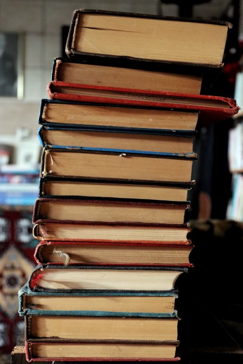 Free A tall stack of vintage books in a cozy, ambient library setting. Stock Photo