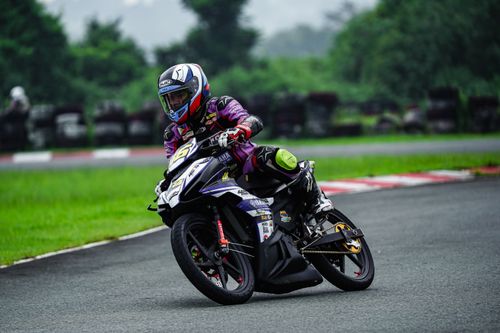 Free Vibrant action shot of a motorcycle racer leaning into a curve on a track. Stock Photo