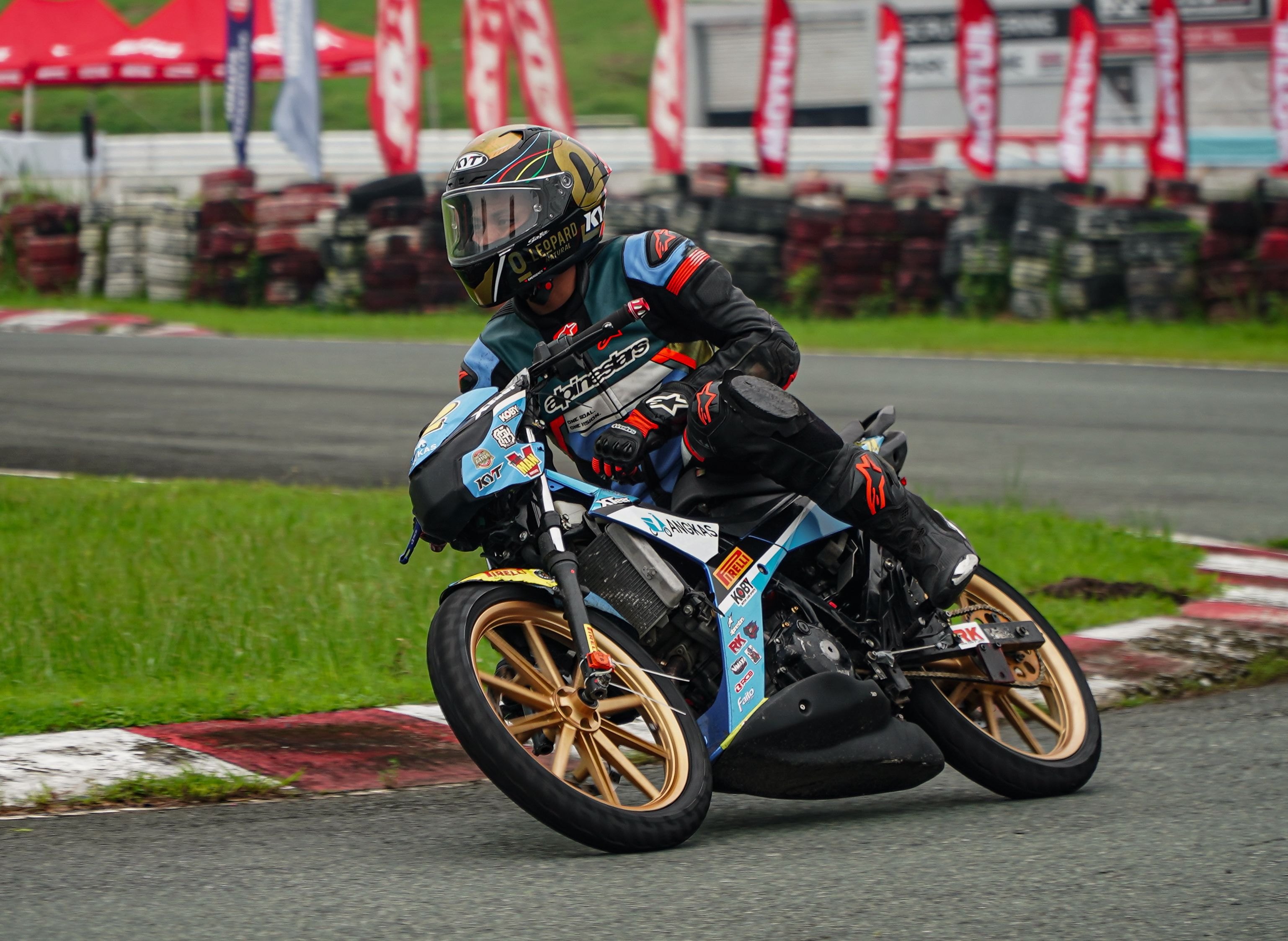 A skilled motorcyclist leaning into a curve at a race track in Tarlac, Philippines.