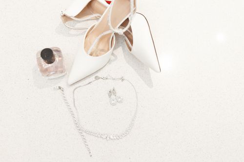 Free A stylish display of white heels, jewelry, and perfume for wedding day elegance. Stock Photo