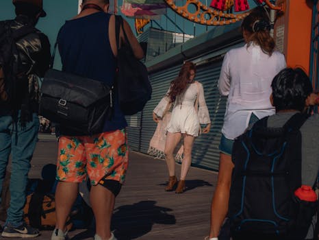 Dynamic fashion shoot capturing a model in a white dress on the Coney Island boardwalk.