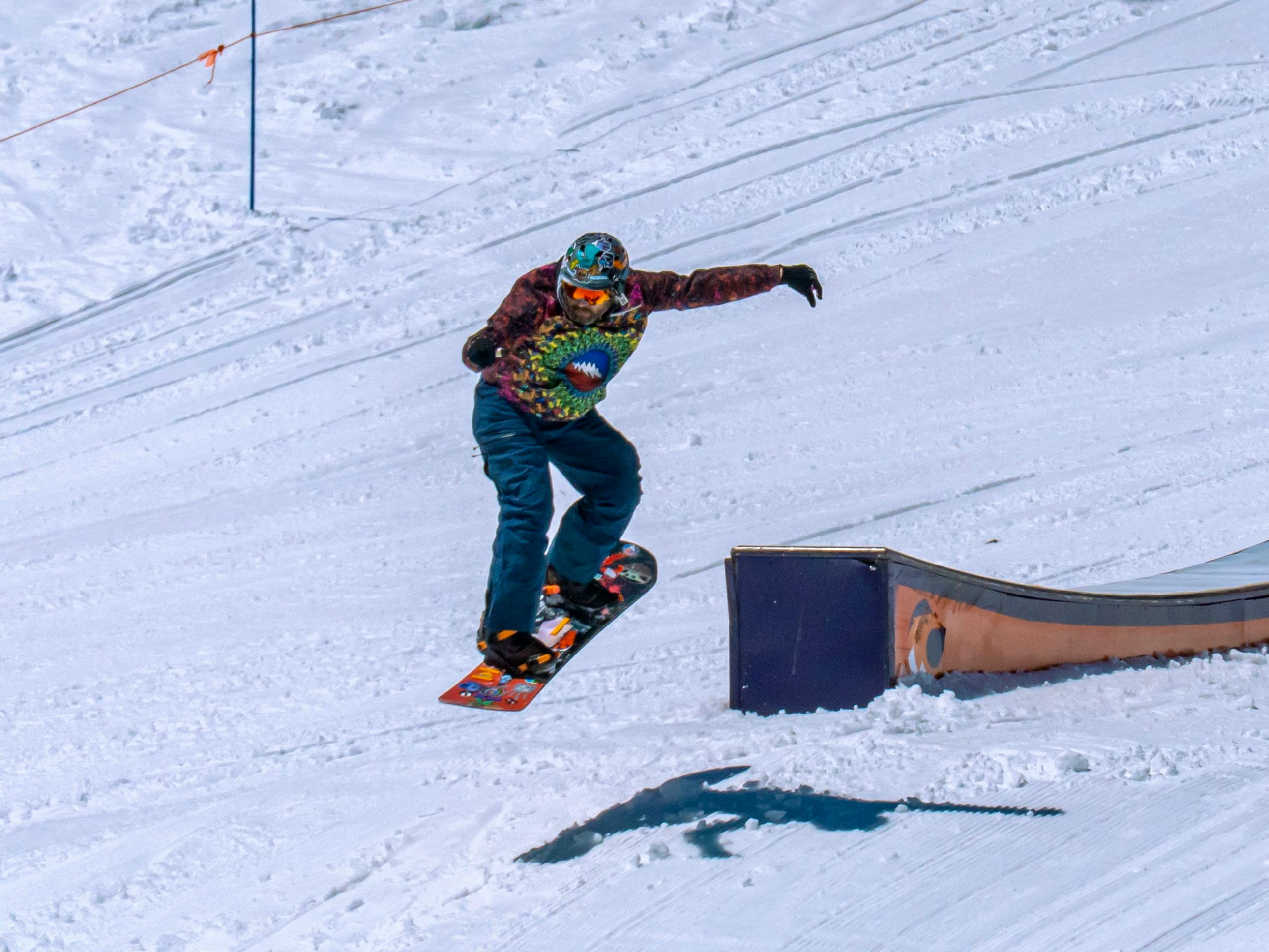Snowboarder performing a winter trick on a rail in a snowy terrain park in Lake Tahoe, USA.